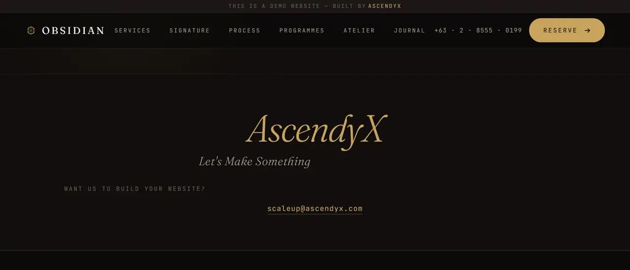 The AscendyX block near the foot of the demo page, the wordmark in brass italic serif above a line reading Let's Make Something, a mono line reading Want us to build your website? and an email link, all on a near black ground